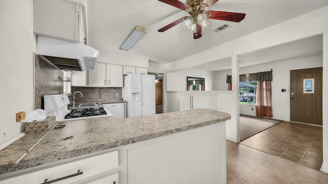 212 E Rentz St, Weatherford, TX 76086 - kitchen with white fridge with ice dispenser, a peninsula, a ceiling fan, tasteful backsplash, and white cabinetry