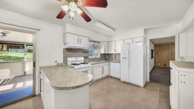 212 E Rentz St, Weatherford, TX 76086 - kitchen with white appliances, a peninsula, decorative backsplash, ceiling fan, and white cabinetry