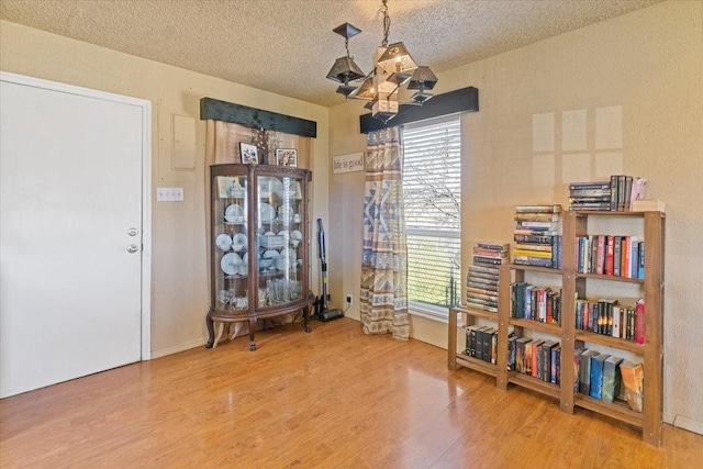 1320 Laredo Dr, Granbury, TX 76048 - sitting room with plenty of natural light, wood finished floors, a textured ceiling, and a chandelier