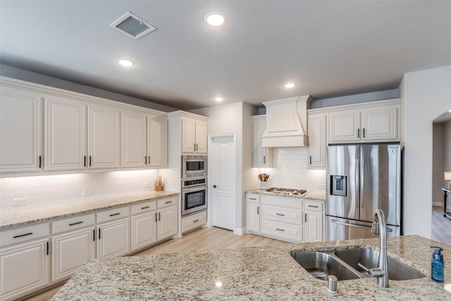 1421 Cedar Creek Dr, Anna, TX 75409 - kitchen with stainless steel appliances, a sink, wall chimney exhaust hood, backsplash, and white cabinets