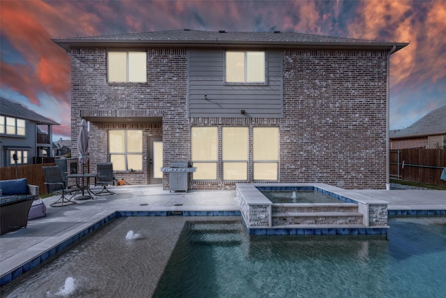 1421 Cedar Creek Dr, Anna, TX 75409 - back of house at dusk featuring a patio area, brick siding, and an in-ground hot tub