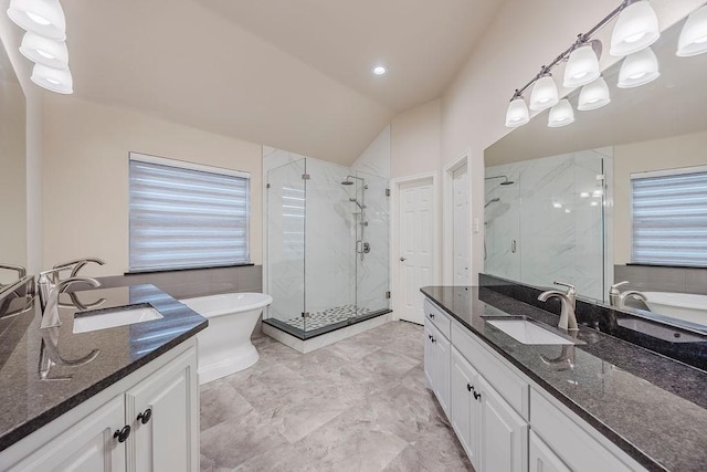 230 Mitchell Blvd, Weatherford, TX 76087 - bathroom featuring two vanities, a marble finish shower, a freestanding bath, lofted ceiling, and healthy amount of natural light