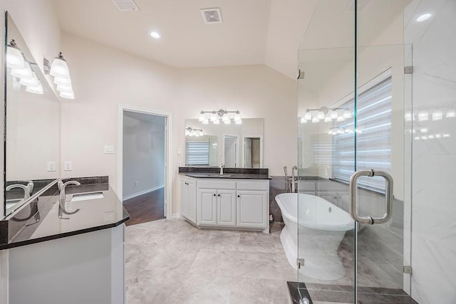 230 Mitchell Blvd, Weatherford, TX 76087 - full bath with two vanities, a freestanding tub, lofted ceiling, and a stall shower