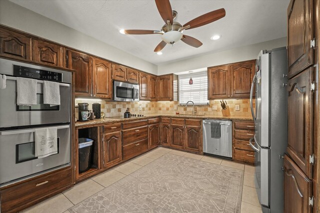 3701 Knob Hill Dr, Plano, TX 75023 - kitchen with appliances with stainless steel finishes, a sink, backsplash, a ceiling fan, and light tile patterned floors