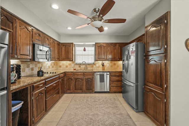 3701 Knob Hill Dr, Plano, TX 75023 - kitchen with appliances with stainless steel finishes, a ceiling fan, backsplash, a sink, and light stone counters