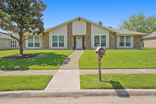 3701 Knob Hill Dr, Plano, TX 75023 - mid-century modern home featuring a front lawn, a chimney, and brick siding
