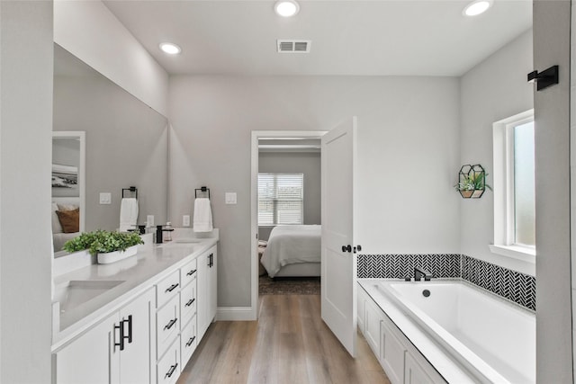 80 Dublin Cir, Gordonville, TX 76245 - ensuite bathroom with double vanity, a garden tub, recessed lighting, wood finished floors, and baseboards