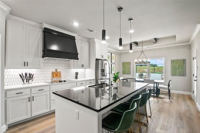 80 Dublin Cir, Gordonville, TX 76245 - kitchen featuring ventilation hood, stainless steel fridge, decorative backsplash, a center island with sink, and black electric cooktop