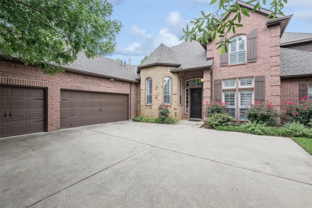 2211 Creek Crossing Dr, Corinth, TX 76210 - french country style house featuring roof with shingles, brick siding, driveway, and an attached garage