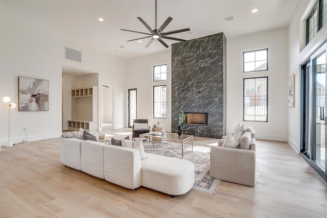 4513 Fair Creek Ter, Fort Worth, TX 76008 - living area featuring healthy amount of natural light, a towering ceiling, recessed lighting, a high end fireplace, and light wood-type flooring