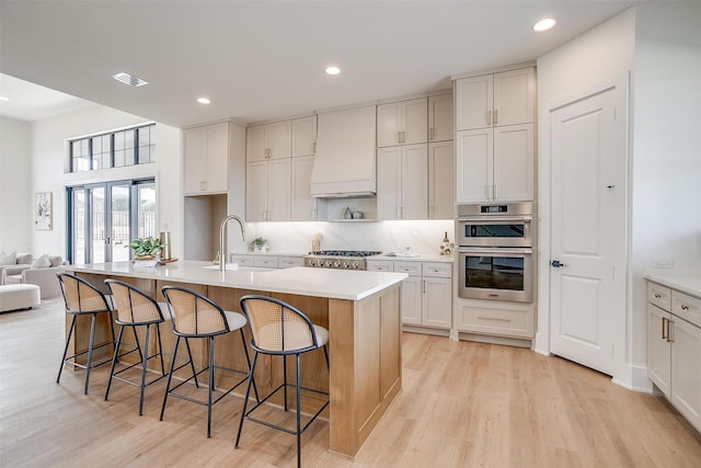 4513 Fair Creek Ter, Fort Worth, TX 76008 - kitchen with appliances with stainless steel finishes, custom range hood, a sink, light wood-style floors, and recessed lighting