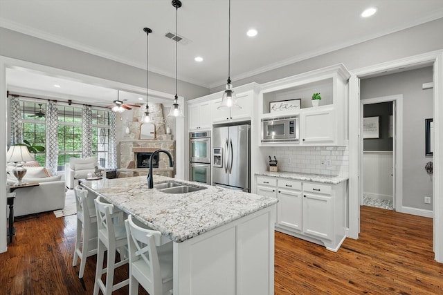 9008 Cypress Creek Rd, Lantana, TX 76226 - kitchen featuring appliances with stainless steel finishes, a sink, open floor plan, a ceiling fan, and decorative backsplash