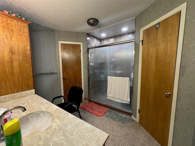 1402 Clarks Dr, Abilene, TX 79602 - bathroom with a shower stall, vanity, a textured ceiling, and tile patterned flooring