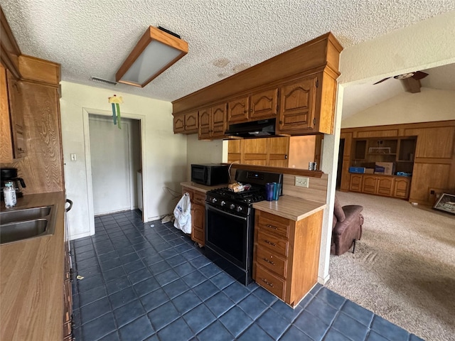 1402 Clarks Dr, Abilene, TX 79602 - kitchen with black appliances, under cabinet range hood, light countertops, dark tile patterned flooring, and a sink