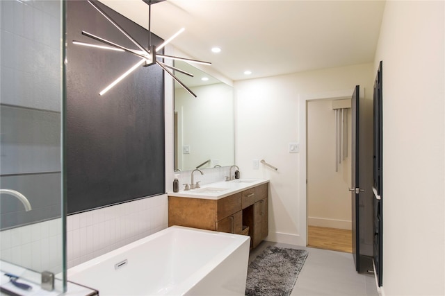 729 Bizerte Ave, Dallas, TX 75224 - bathroom with double vanity, a bathtub, recessed lighting, a chandelier, and baseboards