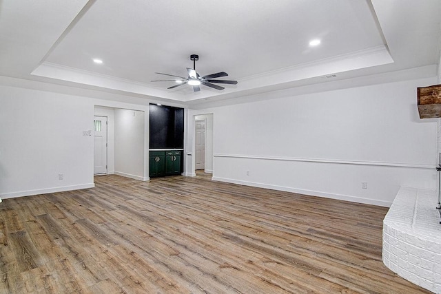 715 Pheasant Run, Burleson, TX 76028 - unfurnished living room featuring a tray ceiling, wood finished floors, ceiling fan, ornamental molding, and baseboards