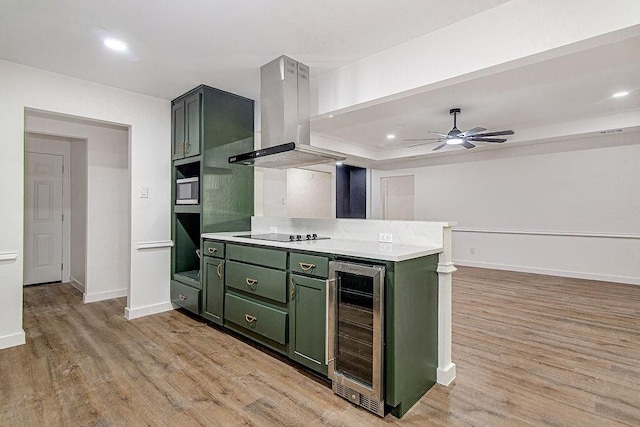 715 Pheasant Run, Burleson, TX 76028 - kitchen with green cabinets, wine cooler, wall chimney range hood, light wood-style flooring, and recessed lighting