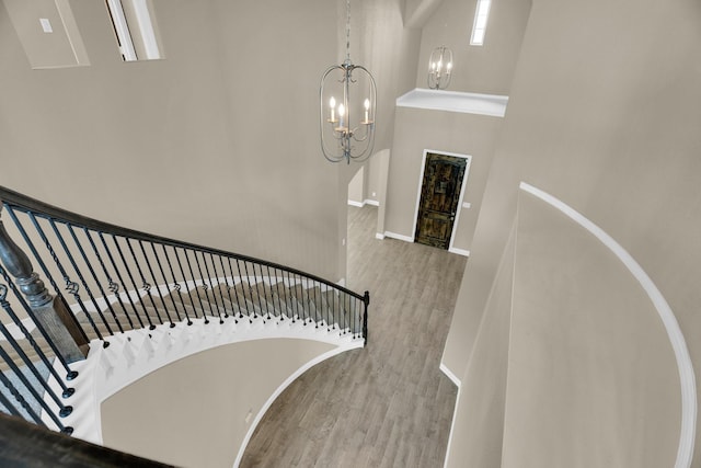 449 Hillstone Dr, Midlothian, TX 76065 - stairway featuring wood finished floors, a chandelier, baseboards, and a towering ceiling