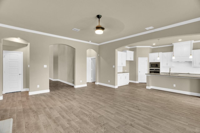 449 Hillstone Dr, Midlothian, TX 76065 - unfurnished living room with a sink, arched walkways, baseboards, wood finished floors, and ornamental molding