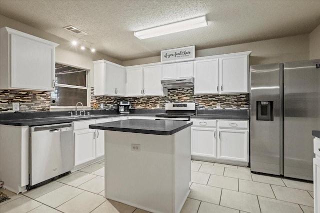 4325 Falcon Dr, Sherman, TX 75092 - kitchen with appliances with stainless steel finishes, under cabinet range hood, white cabinetry, tasteful backsplash, and a textured ceiling