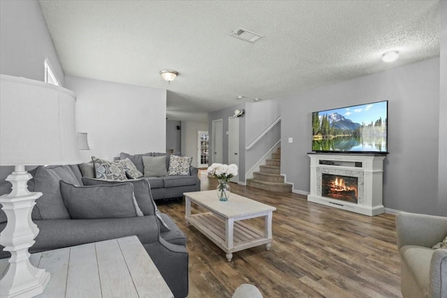 4325 Falcon Dr, Sherman, TX 75092 - living room featuring wood finished floors, a textured ceiling, a lit fireplace, and baseboards