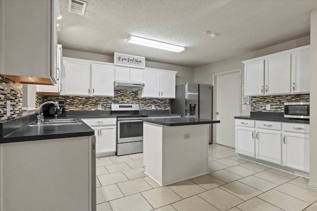 4325 Falcon Dr, Sherman, TX 75092 - kitchen with stainless steel appliances, a sink, under cabinet range hood, decorative backsplash, and white cabinets