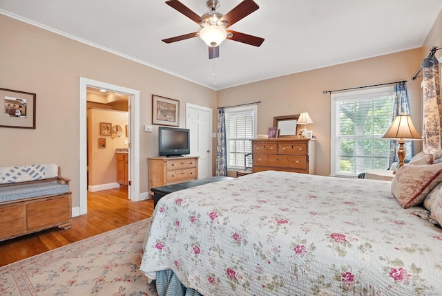 1125 Sayles Blvd, Abilene, TX 79605 - bedroom with wood finished floors, multiple windows, baseboards, ornamental molding, and ensuite bath