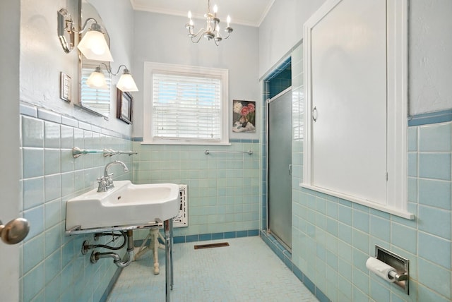 1125 Sayles Blvd, Abilene, TX 79605 - full bath featuring tile walls, a stall shower, a sink, a chandelier, and tile patterned flooring