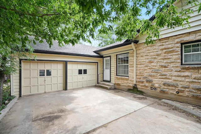 1125 Sayles Blvd, Abilene, TX 79605 - view of front of property featuring stone siding, driveway, an attached garage, and roof with shingles