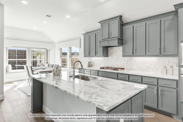 4031 Zina Ln, Prosper, TX 75078 - kitchen featuring gray cabinets, stainless steel gas cooktop, a sink, lofted ceiling, and backsplash