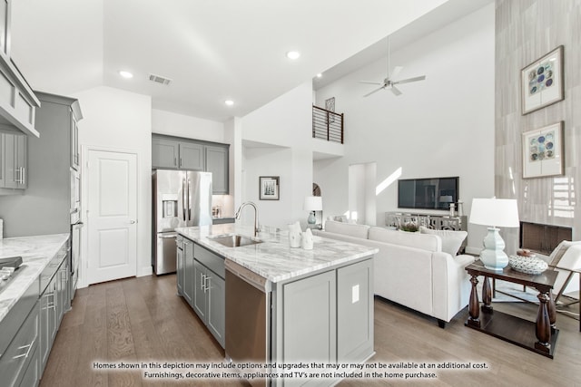 4031 Zina Ln, Prosper, TX 75078 - kitchen with gray cabinetry, appliances with stainless steel finishes, a sink, high vaulted ceiling, and dark wood finished floors