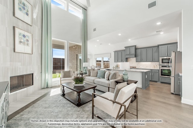 4031 Zina Ln, Prosper, TX 75078 - living area with healthy amount of natural light, light wood-type flooring, a towering ceiling, and recessed lighting