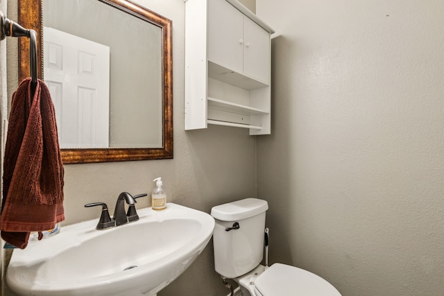 412 Kyle Ln, Lewisville, TX 75067 - bathroom with a sink, toilet, and a textured wall