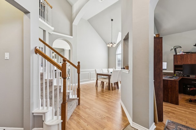 412 Kyle Ln, Lewisville, TX 75067 - entrance foyer featuring light wood-style flooring, high vaulted ceiling, arched walkways, a chandelier, and stairway