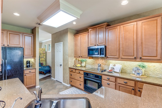 12744 Concho Dr, Frisco, TX 75033 - kitchen with black appliances, light stone counters, decorative backsplash, recessed lighting, and baseboards