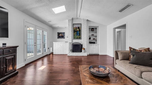8534 Vista View Dr, Dallas, TX 75243 - living area featuring a fireplace, hardwood / wood-style flooring, vaulted ceiling, a skylight, and built in shelves