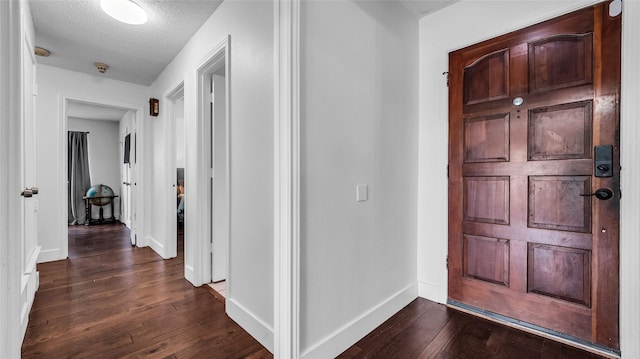 8534 Vista View Dr, Dallas, TX 75243 - entryway featuring dark wood-type flooring, a textured ceiling, and baseboards