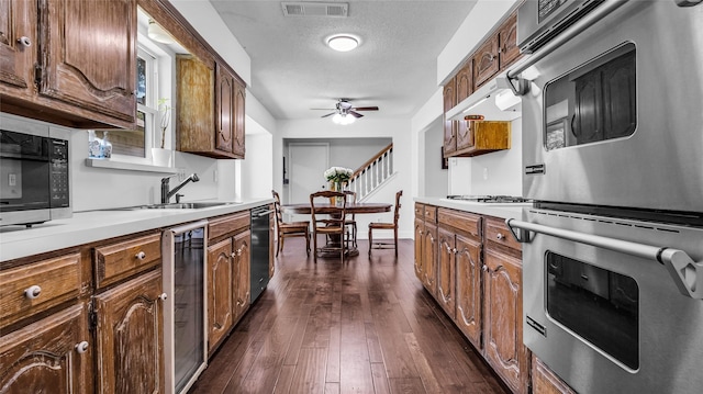 8534 Vista View Dr, Dallas, TX 75243 - kitchen featuring double oven, dishwasher, a ceiling fan, a sink, and dark wood-style floors