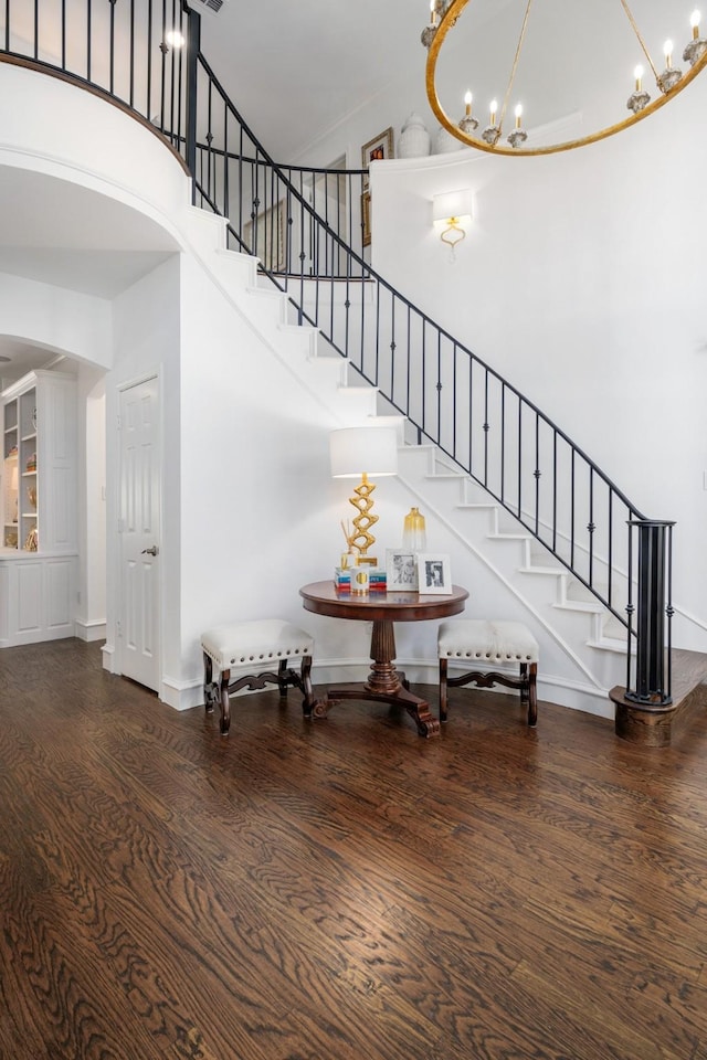 4009 Tave Ct, Arlington, TX 76016 - stairs featuring a high ceiling, a chandelier, wood finished floors, baseboards, and arched walkways