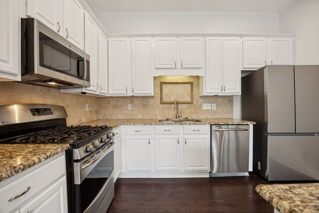 5836 Oram St, Dallas, TX 75206 - kitchen with stainless steel appliances, a sink, crown molding, white cabinetry, and light stone countertops