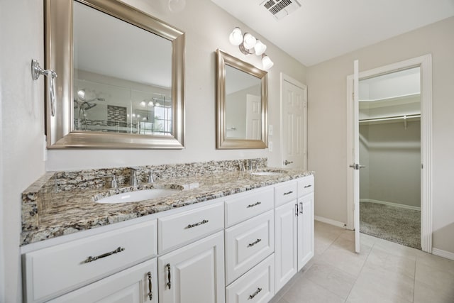 5836 Oram St, Dallas, TX 75206 - bathroom featuring double vanity, baseboards, a walk in closet, and tile patterned flooring