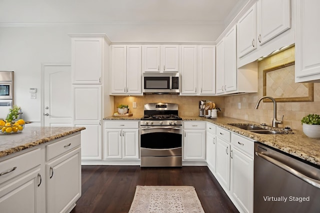 5836 Oram St, Dallas, TX 75206 - kitchen with stainless steel appliances, a sink, crown molding, backsplash, and white cabinetry