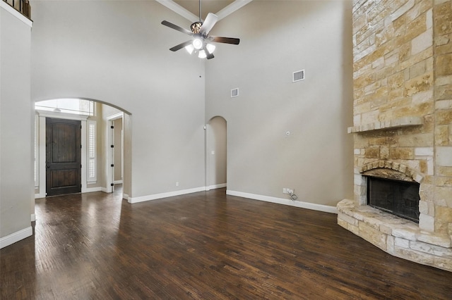 209 Ellis Creek Dr, Weatherford, TX 76085 - unfurnished living room with arched walkways, a high ceiling, ceiling fan, crown molding, and a stone fireplace