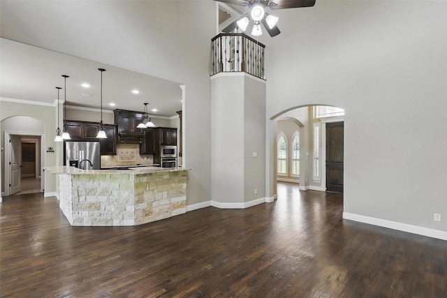 209 Ellis Creek Dr, Weatherford, TX 76085 - kitchen with arched walkways, stainless steel appliances, a ceiling fan, dark brown cabinets, and crown molding