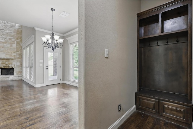 209 Ellis Creek Dr, Weatherford, TX 76085 - mudroom featuring dark wood-style flooring, a chandelier, baseboards, crown molding, and a fireplace