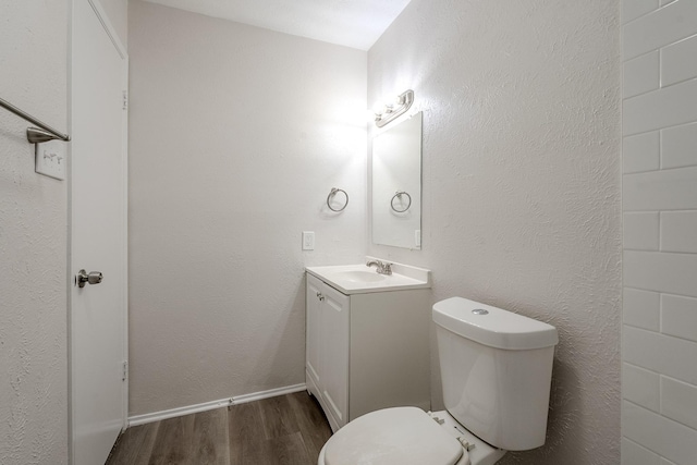 7108 Christie Ln, Dallas, TX 75249 - half bathroom with wood finished floors, vanity, toilet, and baseboards
