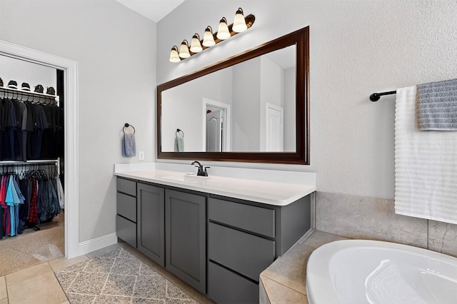 734 Oakleaf Dr, Midlothian, TX 76065 - full bath featuring vanity, a garden tub, a walk in closet, and tile patterned floors