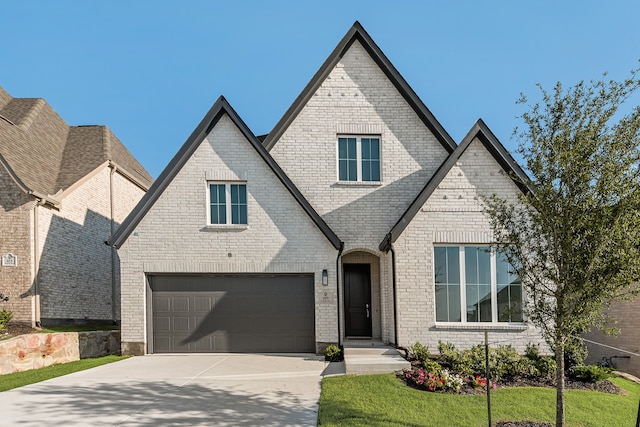 609 Cork Dr, Celina, TX 75009 - french country inspired facade with driveway, an attached garage, and brick siding