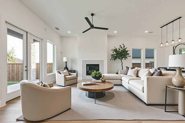609 Cork Dr, Celina, TX 75009 - living area with healthy amount of natural light, wood finished floors, a ceiling fan, a tiled fireplace, and recessed lighting