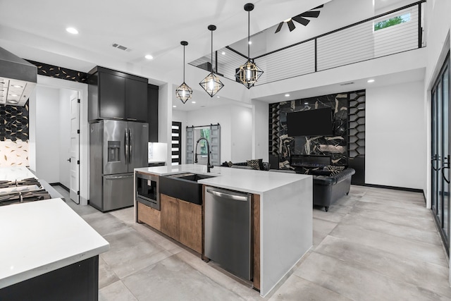 2303 Timber Creek Ct, Cedar Hill, TX 75104 - kitchen featuring appliances with stainless steel finishes, a barn door, dark cabinets, modern cabinets, and a sink
